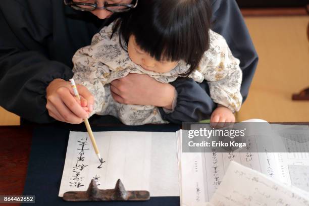 father doing calligraphy with baby - japanese script stock pictures, royalty-free photos & images