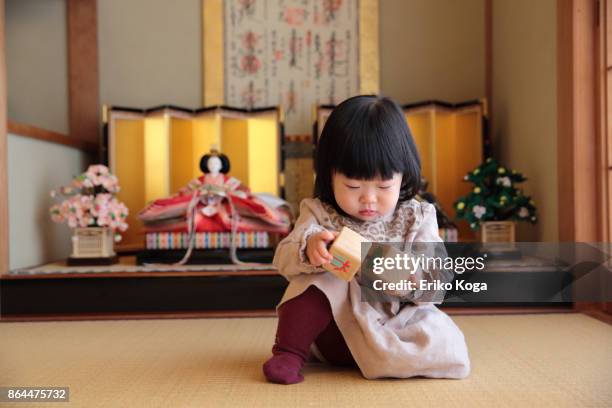 baby playing in front of hina dolls - one baby girl only foto e immagini stock