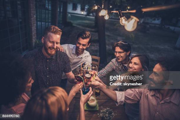 group of happy friends toasting on a night party in the back yard. - drinking in yard stock pictures, royalty-free photos & images