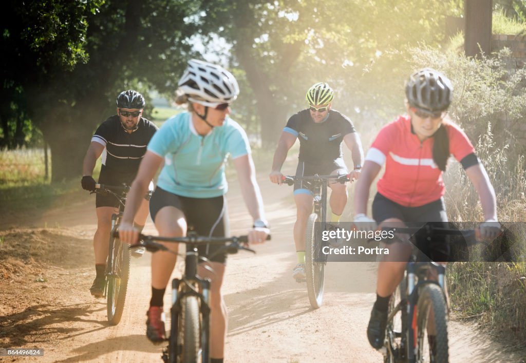 Amici sportivi in bicicletta su strada sterrata