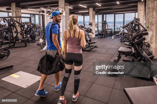 back view of young athletic couple entering the gym and communicating. - entering gym stock pictures, royalty-free photos & images