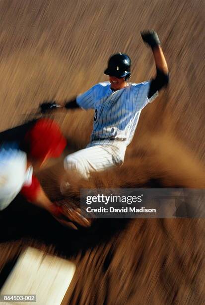baseball, player sliding into third base (blurred motion) - southern european descent stock-fotos und bilder