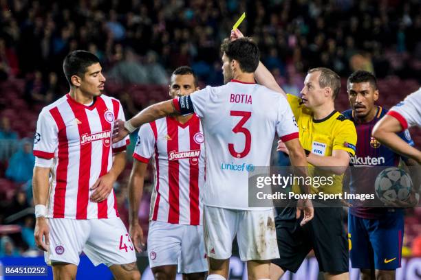 Referee William Collum shows Dimitris Nikolaou of Olympiacos FC the yellow card during the UEFA Champions League 2017-18 match between FC Barcelona...