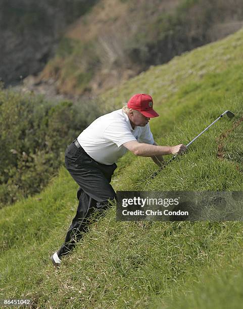 Donald Trump climbs back up to the green after chipping during the third round of the AT&T Pebble Beach National Pro-Am on Pebble Beach Golf Links in...