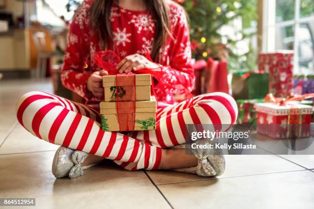 cute young girl sitting with christmas presents - pyjamas stock pictures, royalty-free photos & images