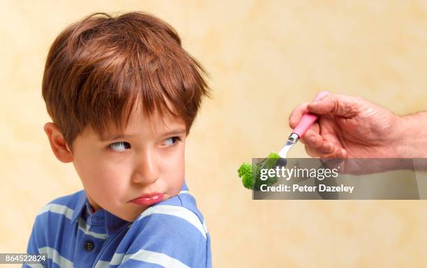 boy refusing to eat his vegetables - persuasion stock pictures, royalty-free photos & images