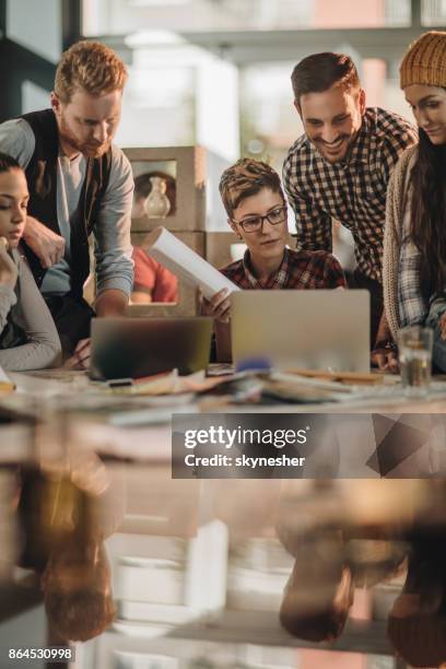 creatieve business team met behulp van de laptop op een bijeenkomst op informele kantoor. - grafisch ontwerper stockfoto's en -beelden