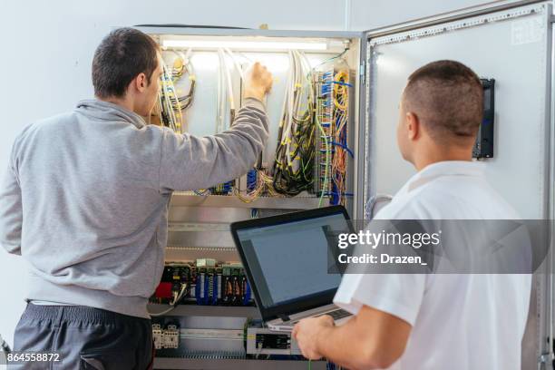 programmers checking the quality of connection in fuse box - electrical fuse box stock pictures, royalty-free photos & images