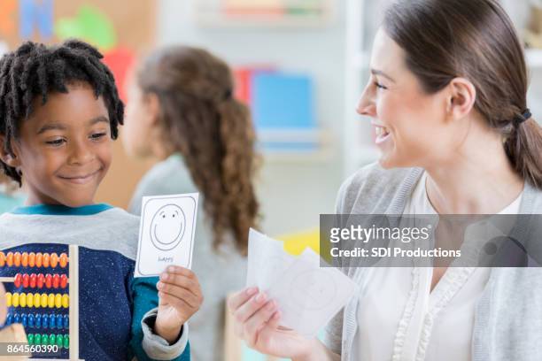 schoolboy learns to express emotions by using emoji flashcard - flash card stock pictures, royalty-free photos & images
