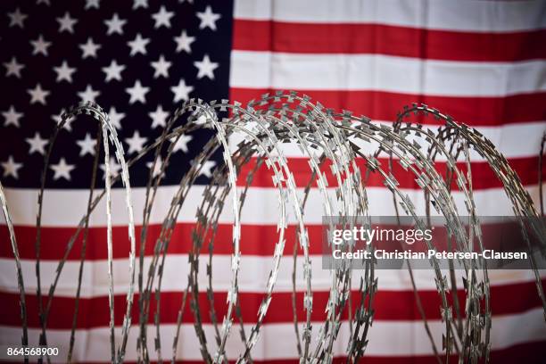 barbed wire and united states national flag - rijksgrens stockfoto's en -beelden