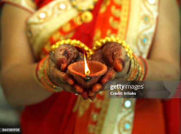 indische frau hält diwali öllampe - diya oil lamp stock-fotos und bilder