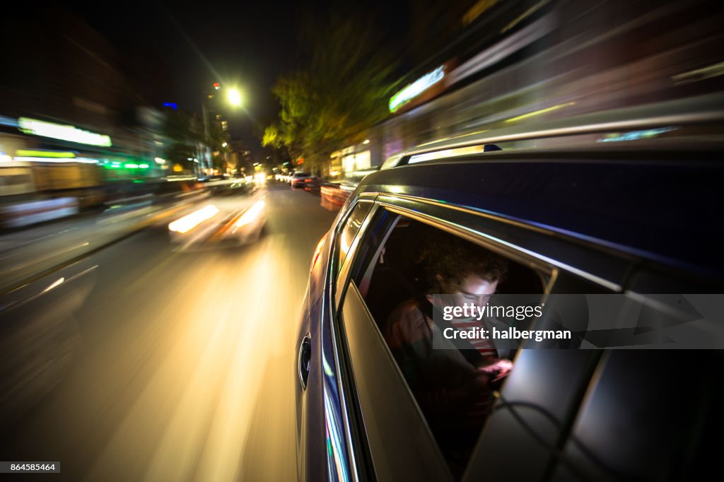在後面的車開車穿過紐約城的女人