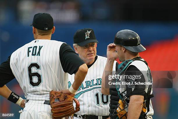 Manager Jeff Torborg of the Florida Marlins talks to shortstop Andy Fox and catcher Mike Redmond against the Detroit Tigers during the MLB game at...