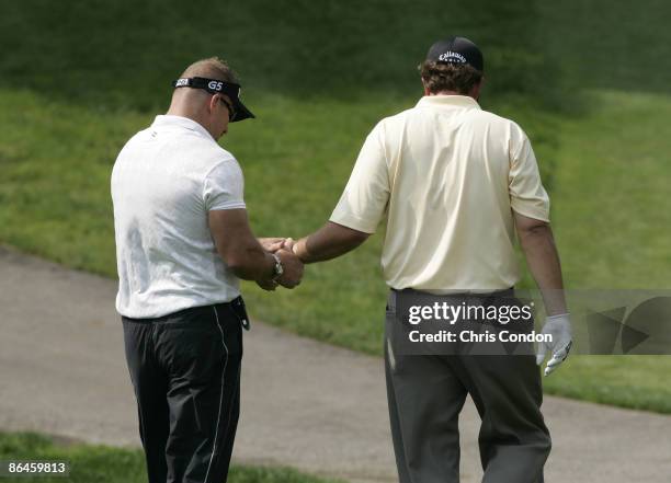 Phil Mickelson gets therapy on his left wrist from Jim Weathers before withdrawing on the 11th hole during the first round of the Memorial Tournament...