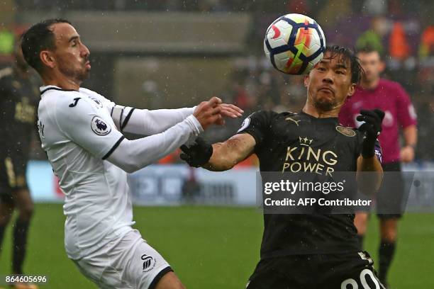 Leicester City's Japanese striker Shinji Okazaki vies with Swansea City's English midfielder Leon Britton during the English Premier League football...