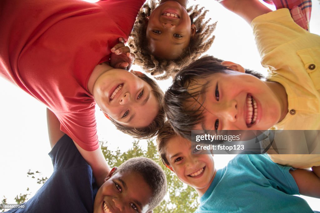 Multi-ethnic group of school children playing on school playground.