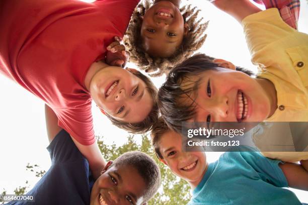 multi-ethnic group of school children playing on school playground. - mixed age range stock pictures, royalty-free photos & images