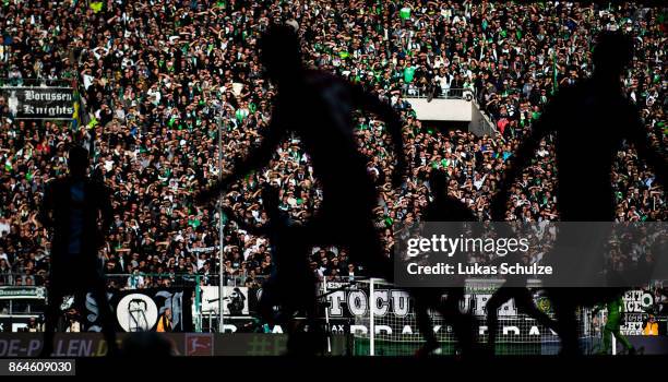 Players in action in front of a bright wall of fans during the Bundesliga match between Borussia Moenchengladbach and Bayer 04 Leverkusen at...