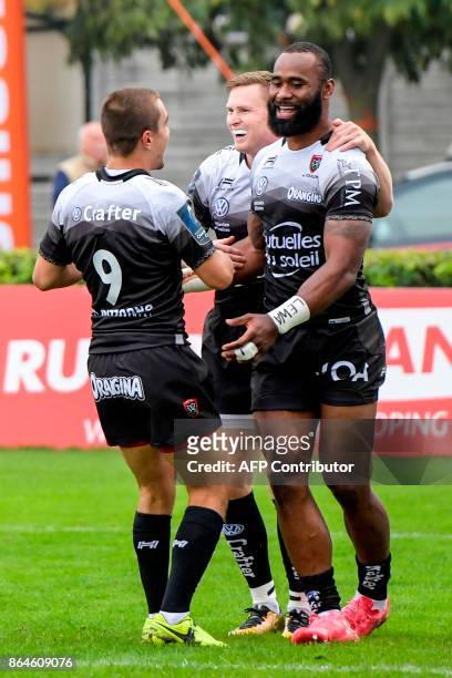 Toulon's Fijian-Australian centre Semi Radradra is congratulated by RC Toulon's French scrumhalf Anthony Meric after scoring a try during the...
