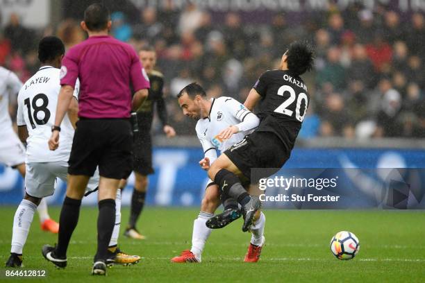 Shinji Okazaki of Leicester City is tackled by Leon Britton of Swansea City during the Premier League match between Swansea City and Leicester City...