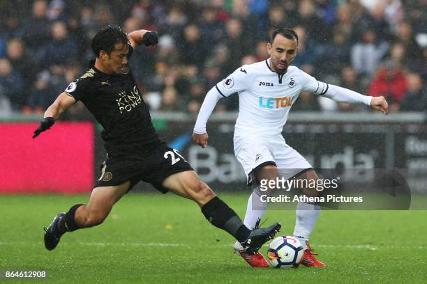 Leon Britton of Swansea City is challenged by Shinji Okazaki of Leicester City during the Premier League match between Swansea City and Leicester...