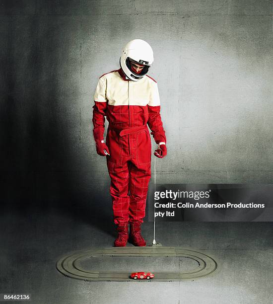 person in racing gear playing with remote control car - pilota di auto da corsa foto e immagini stock
