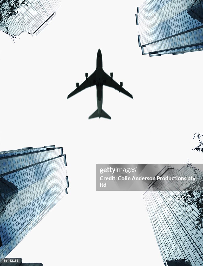 Airplane flying above skyscrapers