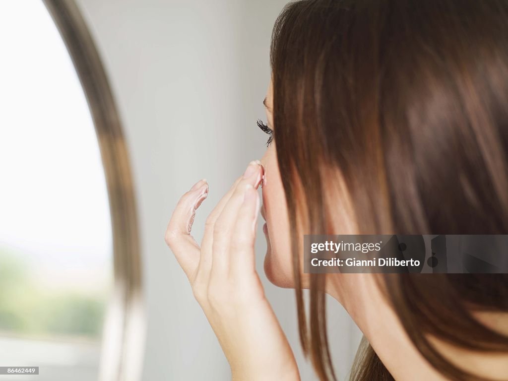 Woman applying moisturizer