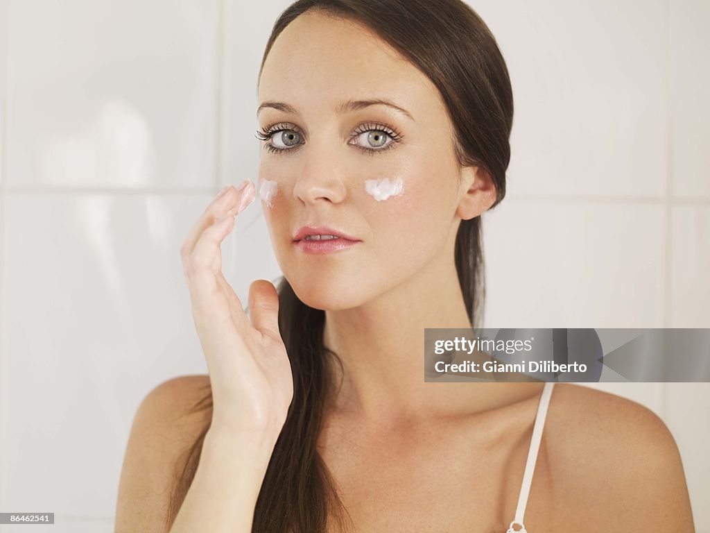 Woman applying moisturizer