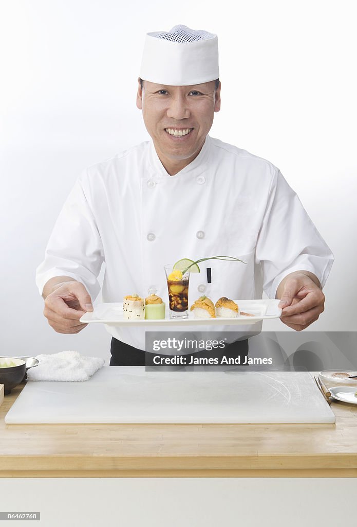 Chef holding nigiri sushi platter