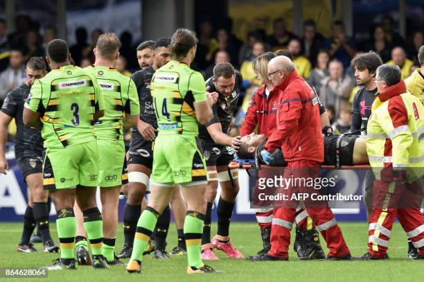 Clermont's French fly-half Camille Lopez is being evacuated on a stretcher after suffering a broken shinbone during the European Rugby Champions Cup...