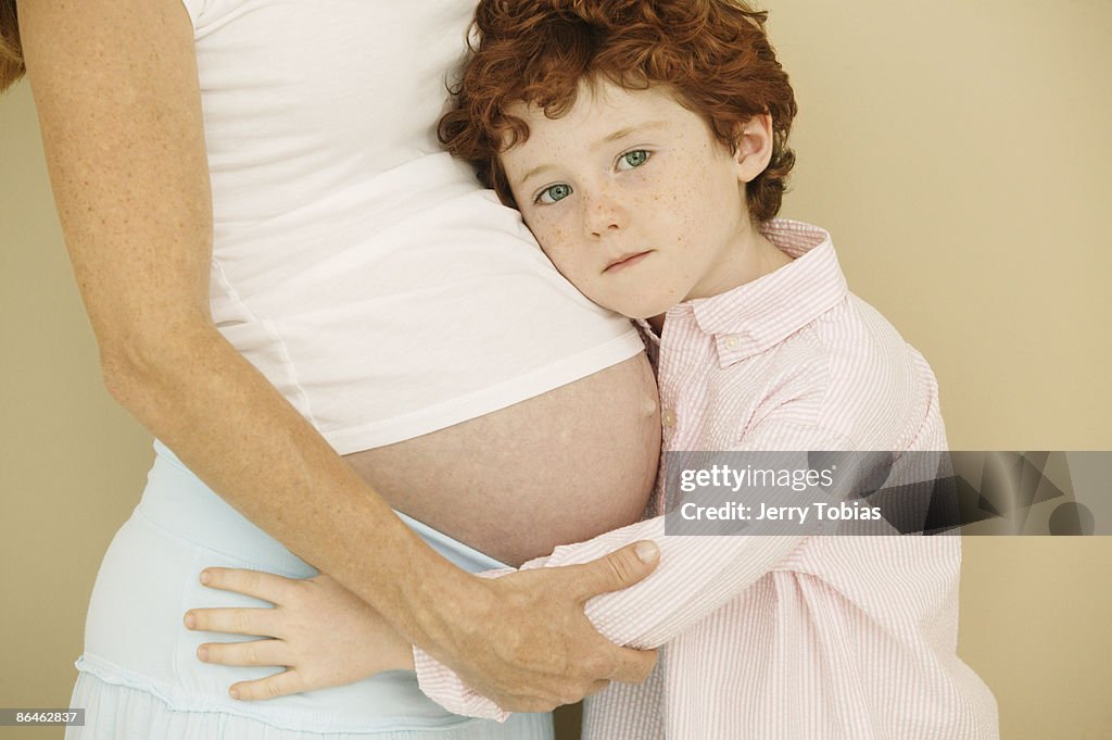 Boy hugging pregnant mom