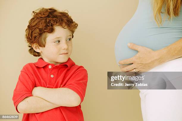 jealous boy looking at pregnant stomach of mother - tobias materna imagens e fotografias de stock