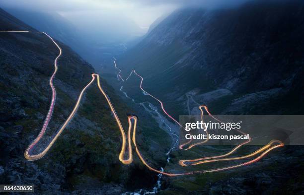 light trails on the trollstigen road in norway at night . . - norway road stock pictures, royalty-free photos & images