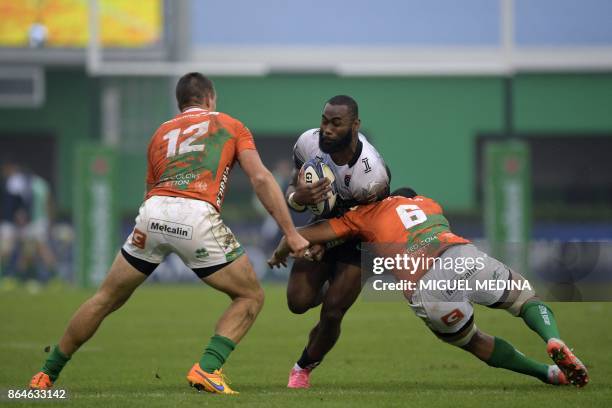 Toulon's from Savu center Semi Radradra is tackled by Benetton Treviso's Italian center Alberto Sgarbi and Benetton Treviso's New Zealander flanker...