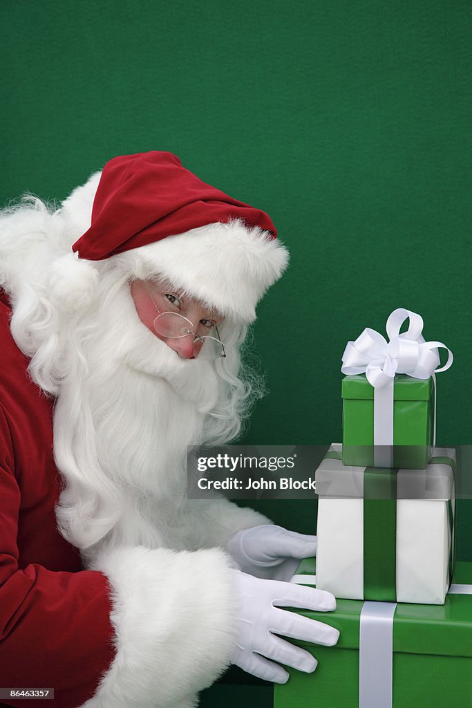 Santa claus touching gifts