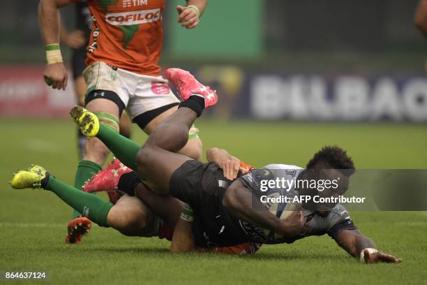 Toulon's Fijian winger Josua Tuisova is tackled by Benetton Treviso's Irish fullback Ian McKinley during the European Rugby Champions Cup match...