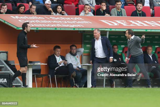 Manuel Baum, coach of Augsburg, and Stefan Reuter, manager of Augsburg, argue with fourth official Patrick Alt during the Bundesliga match between FC...