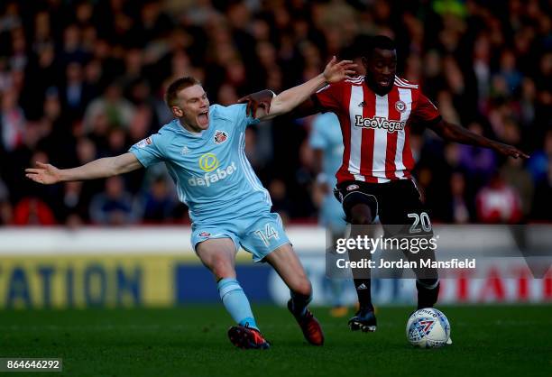 Josh Clarke of Brentford tackles with Duncan Watmore of Sunderland during the Sky Bet Championship match between Brentford and Sunderland at Griffin...