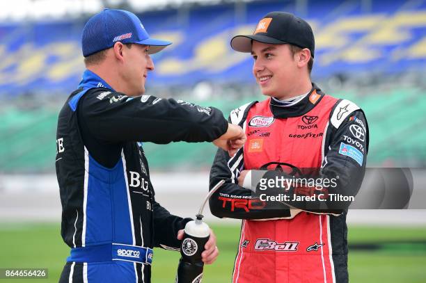 Daniel Hemric, driver of the Blue Gate Bank Chevrolet, talks to Blake Koch, driver of the Breat Cancer Honor & Remember Chevrolet, on the grid during...