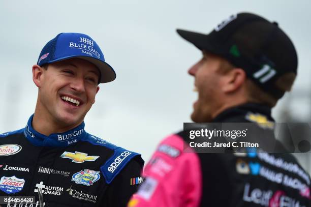 Daniel Hemric, driver of the Blue Gate Bank Chevrolet, talks to Blake Koch, driver of the Breat Cancer Honor & Remember Chevrolet, on the grid during...