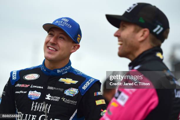 Daniel Hemric, driver of the Blue Gate Bank Chevrolet, talks to Blake Koch, driver of the Breat Cancer Honor & Remember Chevrolet, on the grid during...