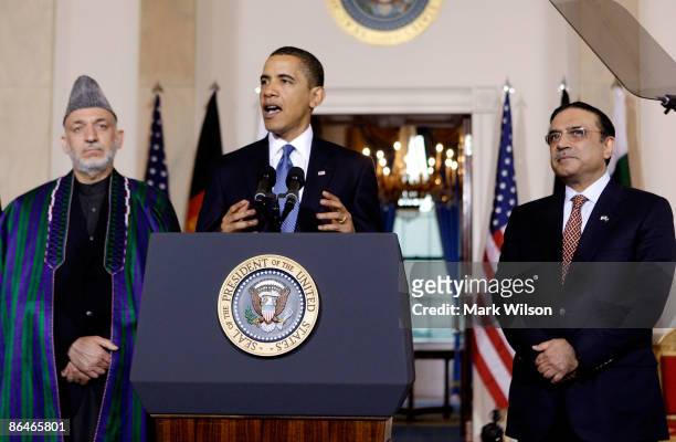President Barack Obama speaks while flanked by Afghan President Hamid Karzai and Pakistani President Asif Ali Zardari after trilateral talks at the...
