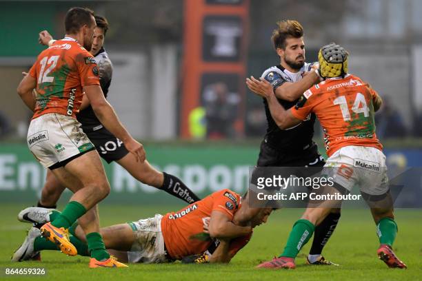 Toulon's French fullback Hugo Bonneval is tackled by Benetton Treviso's Argentinian centre Juan Ignacio Brex and Benetton Treviso's Italian wing...