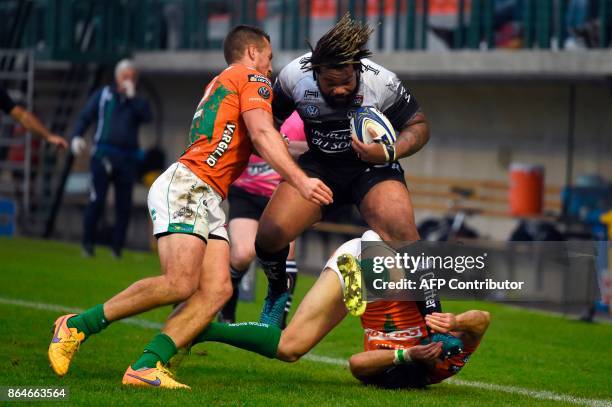 Toulon's French centre Mathieu Bastareaud is tackled by Benetton Treviso's Italian centre Alberto Sgarbi and Benetton Treviso's Irish fullback Ian...