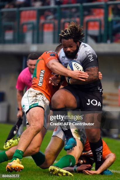 Toulon's French centre Mathieu Bastareaud is tackled by Benetton Treviso's Italian centre Alberto Sgarbi and Benetton Treviso's Irish fullback Ian...