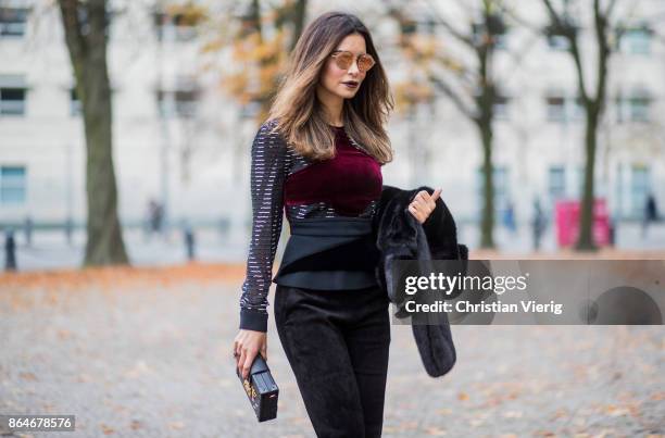 Miryam Labiad wearing Roland Mouret top and pants, black Celine fur jacket, Louis Vuitton clutch, Bulgari sunglasses on October 21, 2017 in Berlin,...