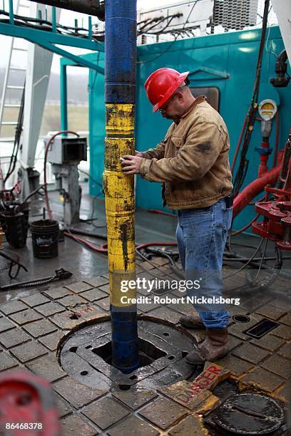 An engineer adjusts a down hole motor used for directional drilling on a natural gas drilling platform in the Barnett Shale on December 18, 2008 in...