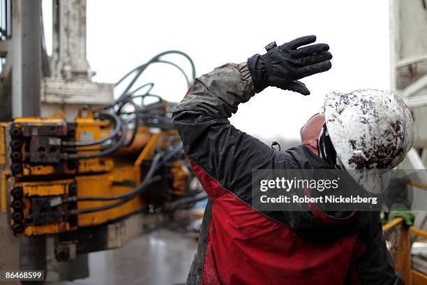 Floor hands move drilling pipe to a storage area on a Barnett Shale natural gas drilling rig in the 18,000 acre grounds of the Dallas-Fort Worth...