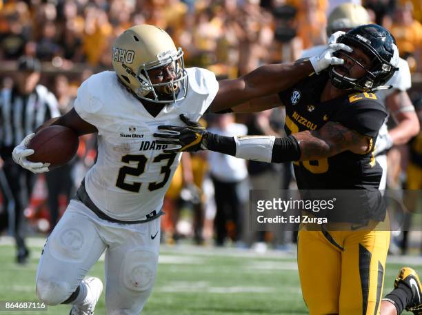 Aaron Duckworth of the Idaho Vandals stiff arms Kaleb Prewett of the Missouri Tigers as he tries to gains extra yards in the second quarter at...